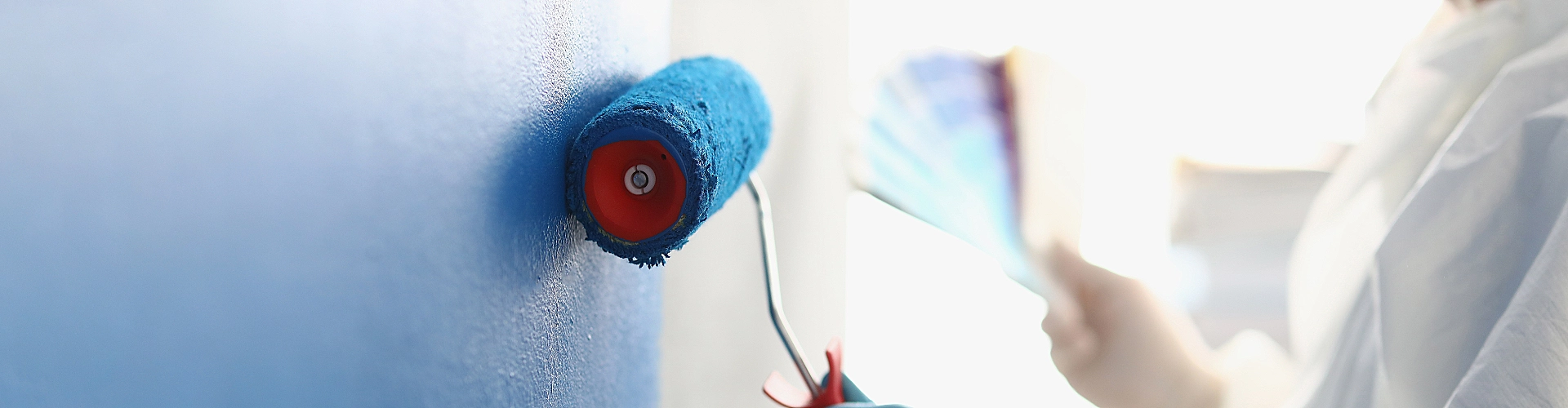 A worker paints a wall during an interior project handled by Paint‑Pro’s.